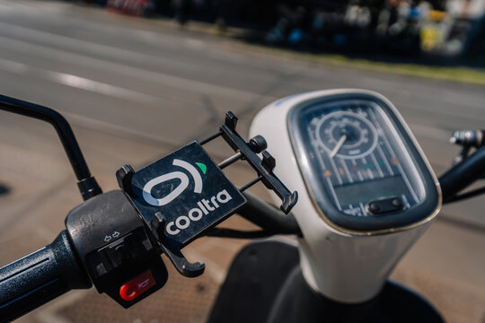 Close-up of a scooter handlebar with a visible cooltra logo and speedometer, showcasing urban transportation in Milan