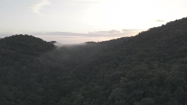 Aerial drone pulling back to reveal sunrise over Mountain, La Vega, Dominican Republic
