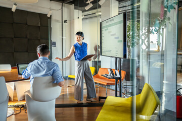 Fototapeta premium Businesswoman presenting project timeline during modern office meeting