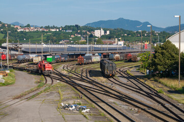 Red freight locomotive moving on tracks in Chiasso railway marshalling yard © Marlon