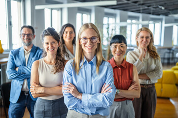Fototapeta premium Diverse business team smiling standing together in open plan office