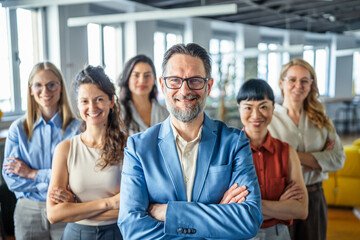 Fototapeta premium Diverse business team smiling with arms crossed in modern office