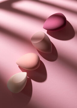 Makeup beauty blender sponges in pink gradient row with shadows