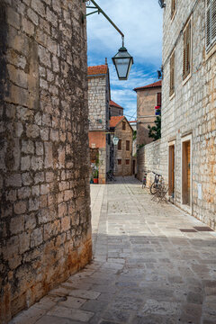 Narrow historic stone street with lantern in Stari Grad old town