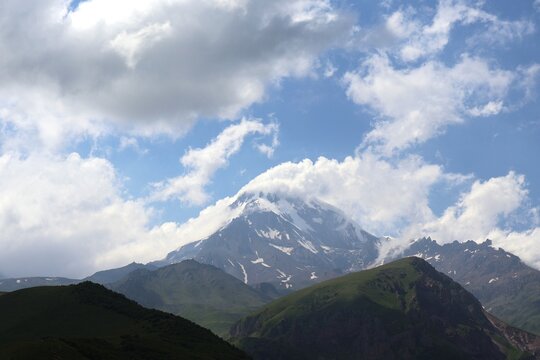 Scenic view of Mount Kazbegi snow capped summit with dramatic cloudscape in Greater Caucasus