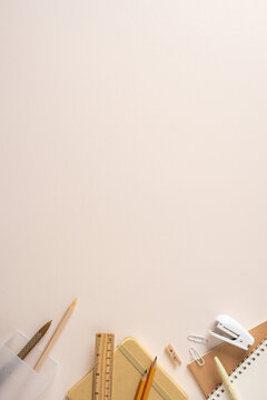 Backtoschool stationery vertical flatlay with notebook pencil ruler and stapler on beige desk for study and imagination