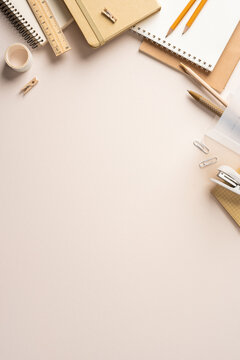 Back to school vertical flatlay with neutral stationery, notebook, pencil and planner on beige desk with clean space