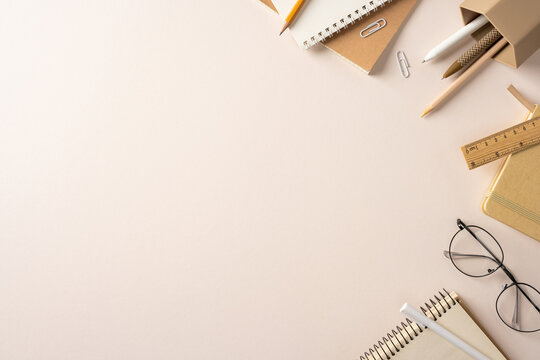 Back to school flat lay with neutral stationery, notebooks, pencils and glasses on a workspace with space for design