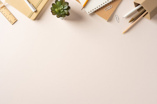 Backtoschool workspace with notebook, pencil, succulent and stationery on a neutral desk for study