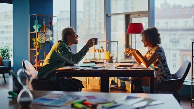 Friends laughing over coffee cinematic office. People relaxing at sunset window