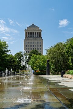 Historic courthouse tower behind fountain and park plaza