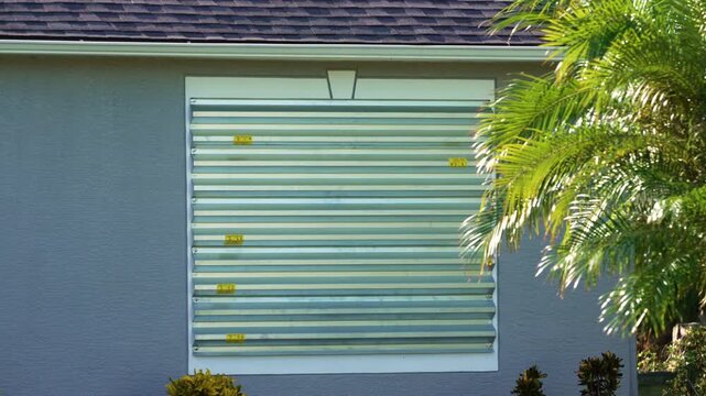 Steel sheets mounted as storm shutters for hurricane protection of house windows. Protective measures before natural disaster in Florida