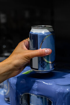 Hand grabbing an aluminum can from multipack
