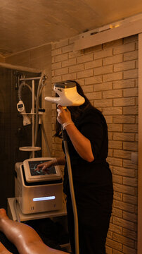 masseuse adjusts massage device. Vacuum roller massage. Dim atmospheric warm light. self-care, grooming, weight loss