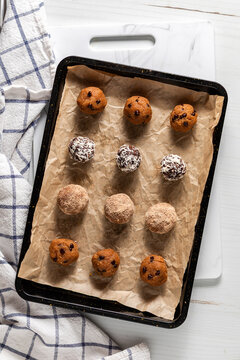 A parchment lined baking tray topped with various kinds of energy balls.