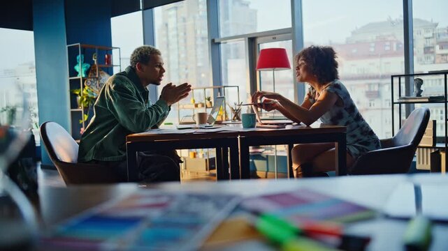 Colleagues debating ideas modern design office. Man woman animated discussion.
