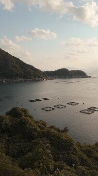 Cinematic panoramic view of the traditional Funaya boat houses in Ine, Kyoto Prefecture, Japan, captured at sunset from the hilltop observation parking area overlooking Ine Bay