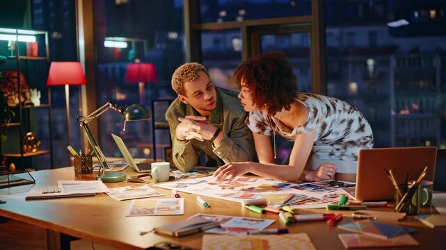 Man woman pointing color swatches brainstorming project. Creative night teamwork