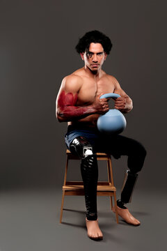 Determined athlete with prosthetic legs training biceps anatomy