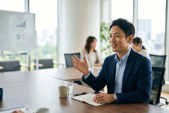 オフィスで会議中に発言する日本人男性 Generative AI