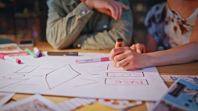 Young designers brainstorming wireframe layout in night office creative teamwork