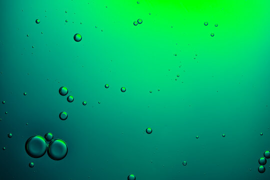 Bubbles rising in abstract green liquid background