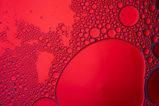 Red oil bubbles floating on water surface texture
