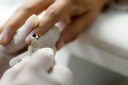 Esthetician manicuring fingernail cuticle using professional nipper