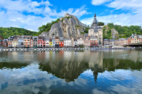 Beautiful idyllic town of Dinant, Belgium. Reflections in a calm river with citadel and gothic church.