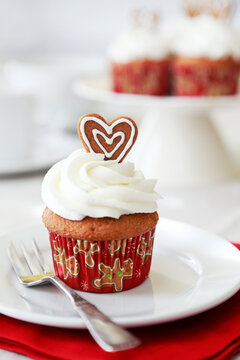 Christmas spice cupcake with vanilla and white chocolate frosting decorated with mini ginger snap heart