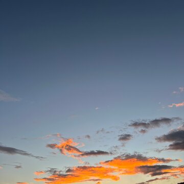 Vibrant sunset sky with orange clouds fading into blue twilight