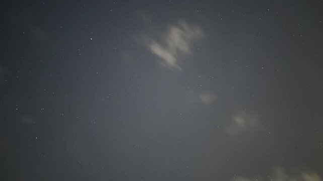 Captivating night sky timelapse showing twinkling stars and soft passing clouds in the wilderness
