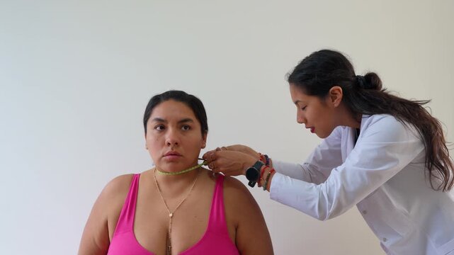Female nutritionist measuring overweight woman's neck circumference