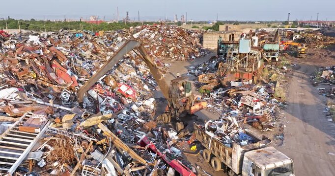 Heavy Material Handler Sorting Scrap Metal at Industrial Recycling Yard