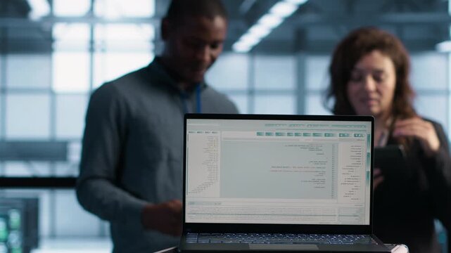 Software developers use laptop in a server room to perform vulnerability scans and verify firewall security, combining vulnerability scanning, vulnerability scan and firewall configuration.