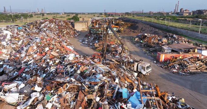 Heavy Material Handler Sorting Scrap Metal at Industrial Recycling Yard