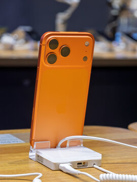 Modern Orange Smartphone Charging on Display Stand