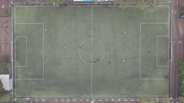 Top-Down Aerial View of Players on Football Field as Drone Hovers Overhead