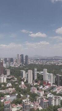 Aerial panoramic view with drone flying backward over Polanco toward Paseo de la Reforma skyline, vertical video, shot in D-Log M