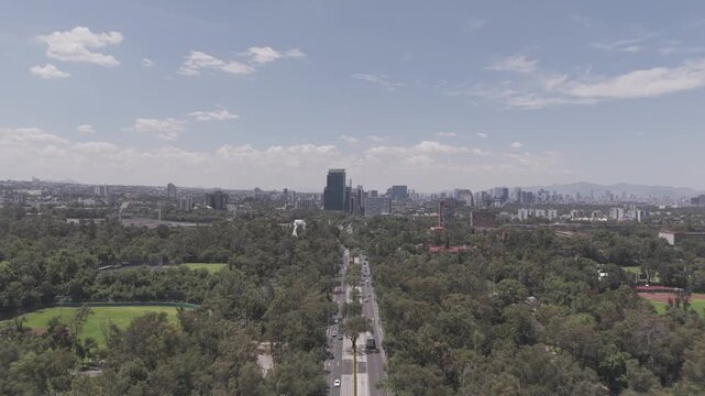 Drone Flies Forward Over Avenida de los Insurgentes Toward Mexico City Skyline, Ciudad Universitaria UNAM. File in Dlog-M