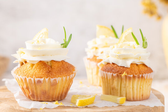 Delicious lemon cupcakes garnished with buttercream and rosemary