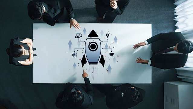 A business team engages in a brainstorming session, focusing on innovative ideas and growth strategies with a rocket graphic symbolizing progress and success. Trope