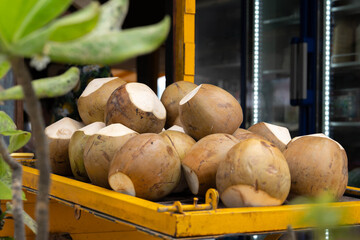 Fresh young coconuts for sale at tropical street market fruit stand © Aisylu