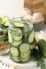 Obraz premium Making pickles. Fresh cucumbers in glass jar and spices on table, closeup
