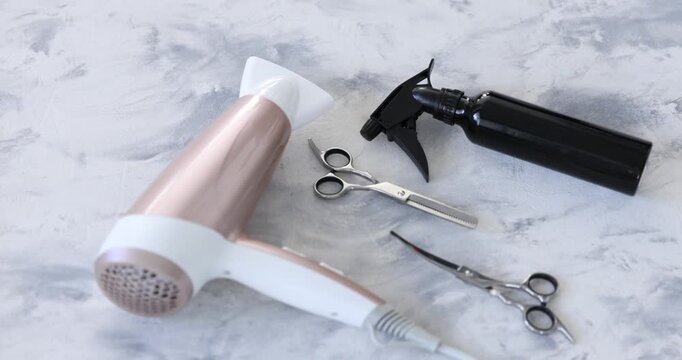 Different hairdresser's tools on textured table, closeup. Camera moving in