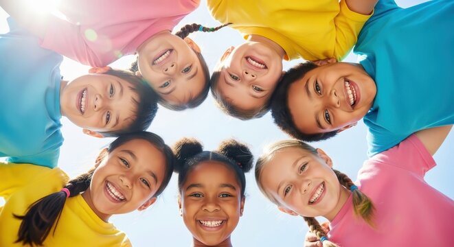 Multi-ethnic Group of Happy Smiling Children in Colorful T-shirts Forming a Circle Under Bright Sunny Sky