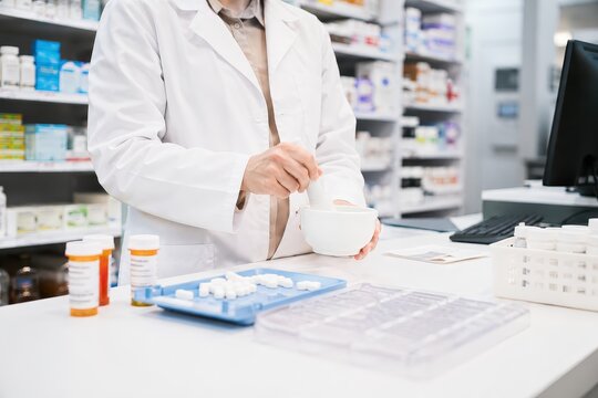 Pharmacist preparing medication in a pharmacy, dispensing pills and capsule
