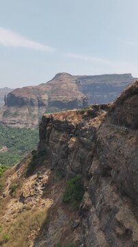 Vertical video aerial of Ratangad fort clifftop plateau Maharashtra India