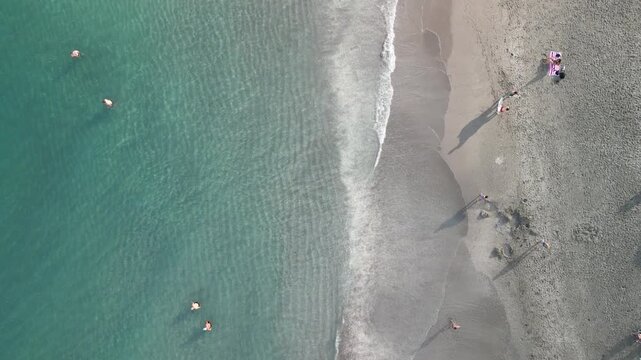 Tourists and locals swimming and playing in the surf along the coast at Juno Beach Pier in Palm Beach County, Florida. 