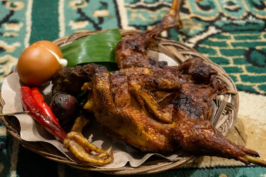 Crispy fried chicken with egg and chili on a traditional woven plate